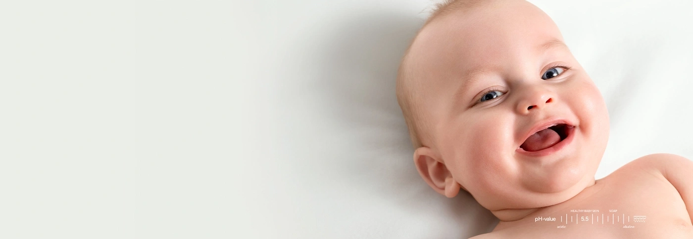 A smiling baby with text about pH value and soap.