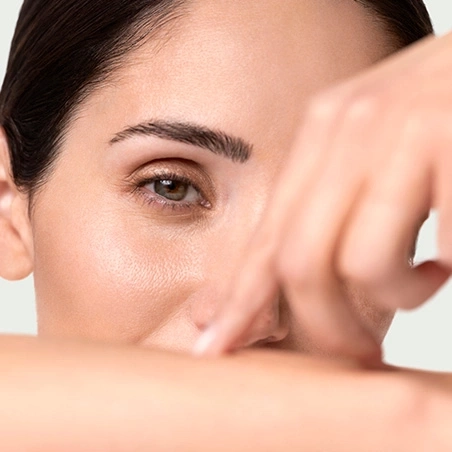Primer plano de un ojo y una mano tocando la cara de una persona