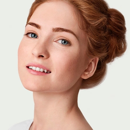 Portrait of a young woman with red hair and blue eyes smiling