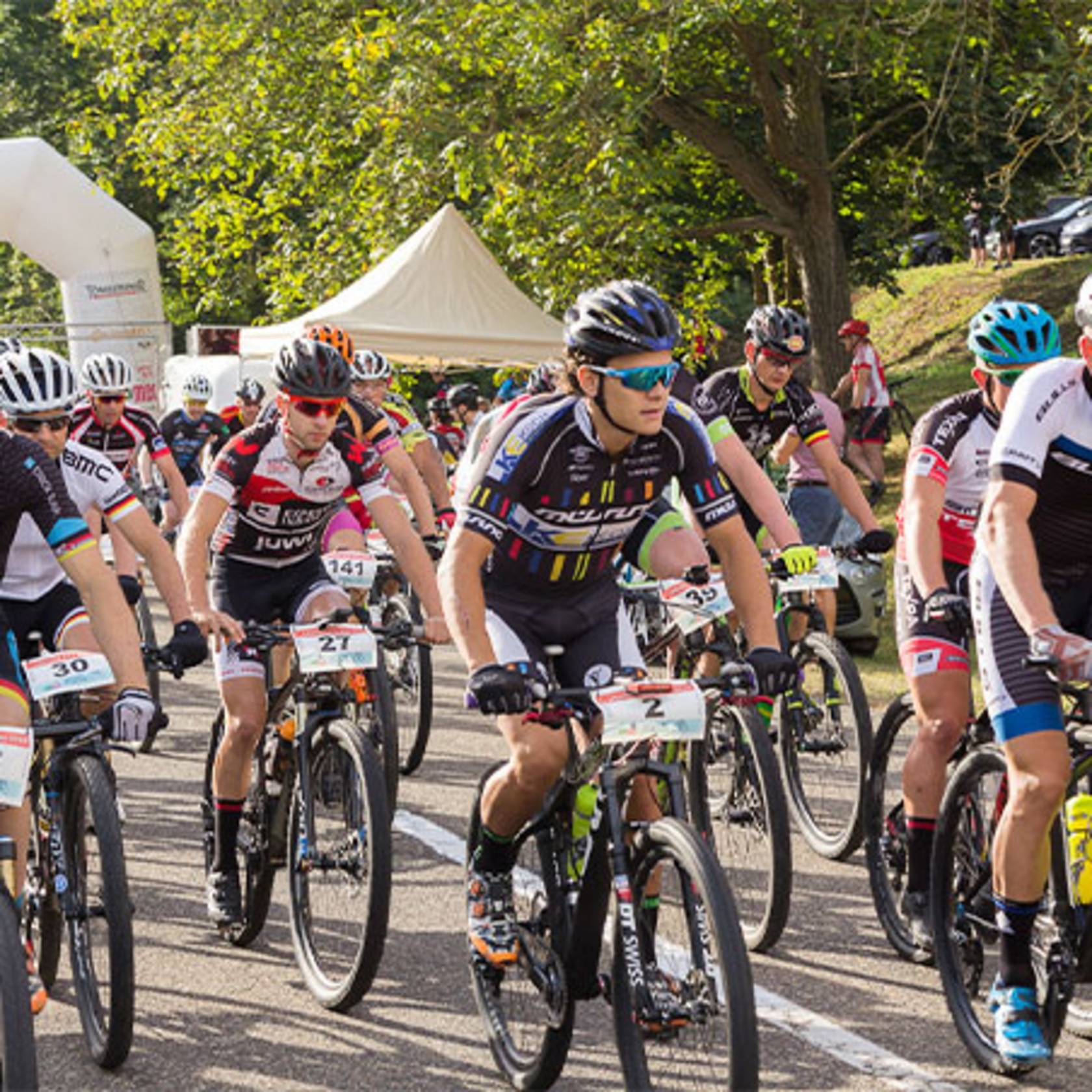 Mountain bike race with many cyclists riding on the road.