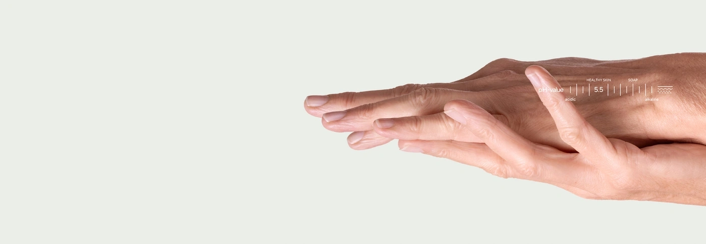 Hands with a pH scale showing healthy skin at 5.5.