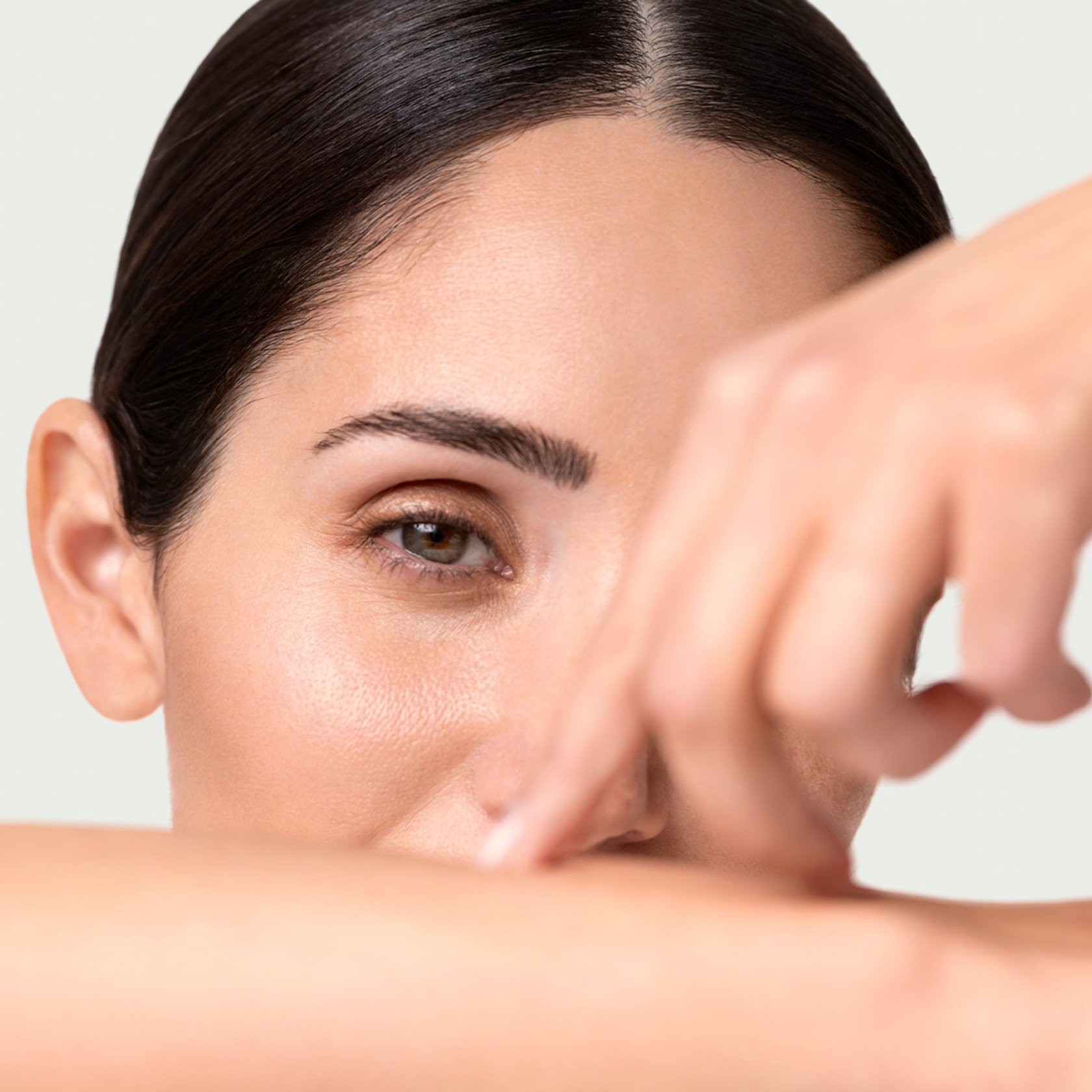 Nahaufnahme einer Frau, die ihre Augen mit der Hand bedeckt, mit einem sanften Blick.