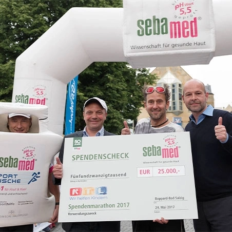 Sebamed donation marathon: check presentation with donation check and people