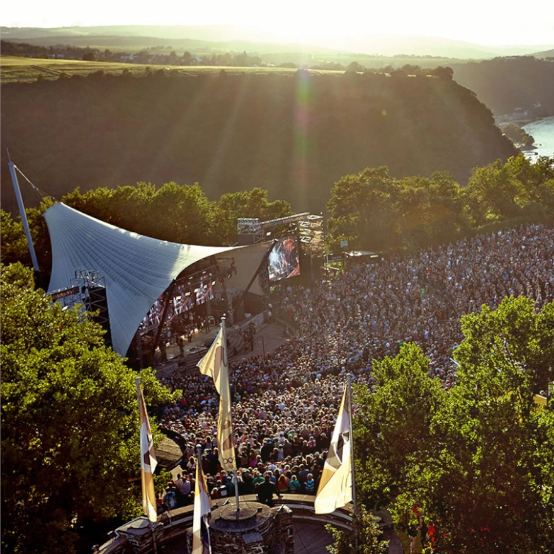 Outdoor concert with a large crowd and a stage.