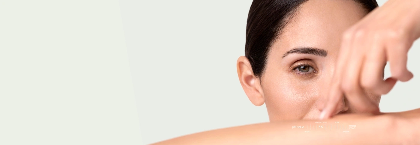Close-up of a woman with a pH value chart showing healthy skin at 5.5.