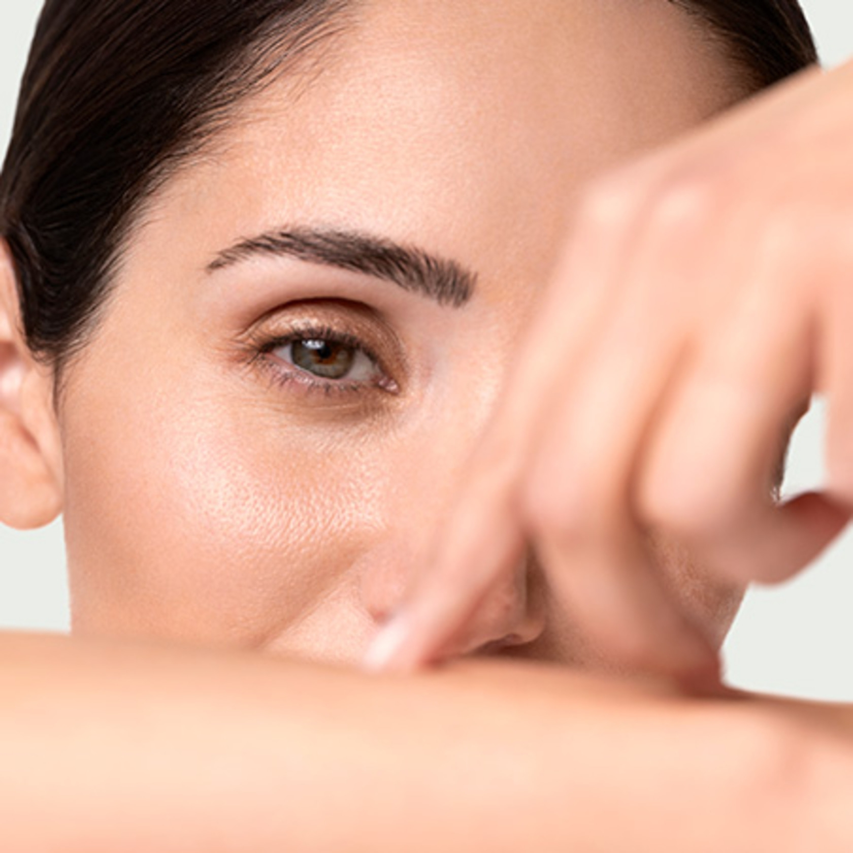 Close-up of an eye and hand touching a person's face