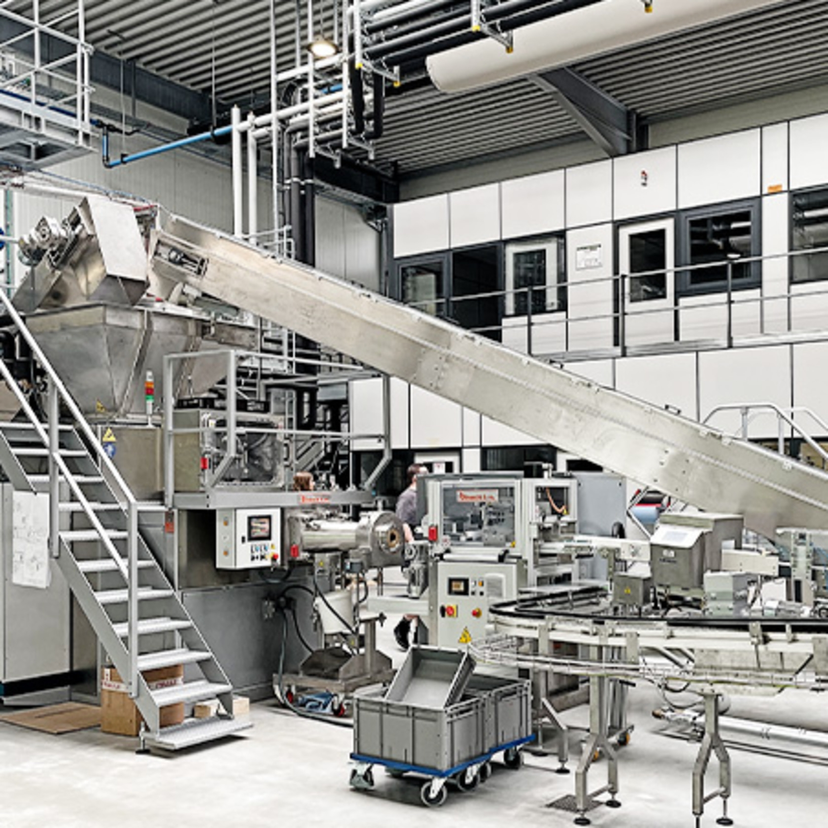 Fábrica con cinta transportadora y equipos de producción en nave