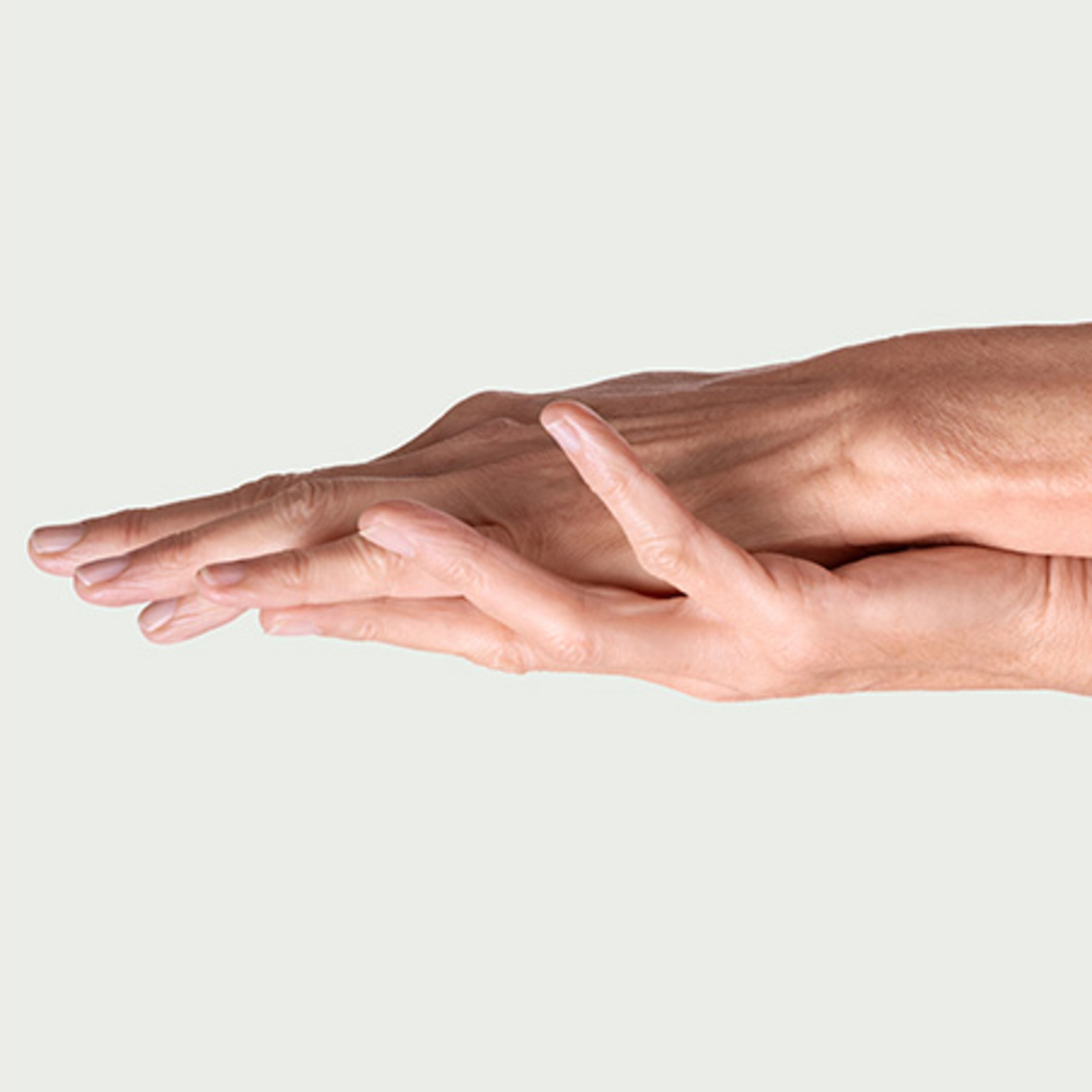Close-up of two hands touching, delicate gesture, light background