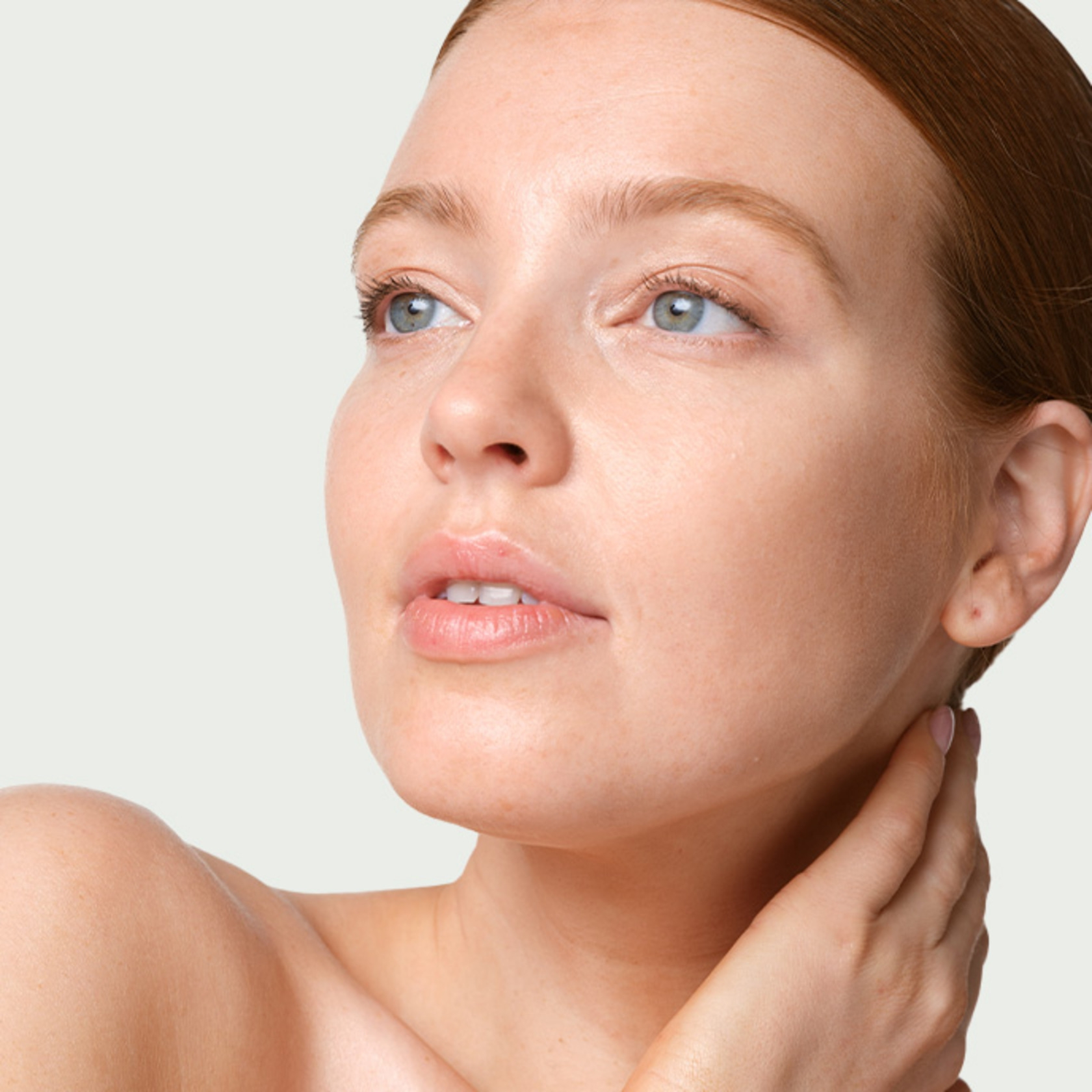 Portrait of a young woman with freckles looking upwards, fair skin