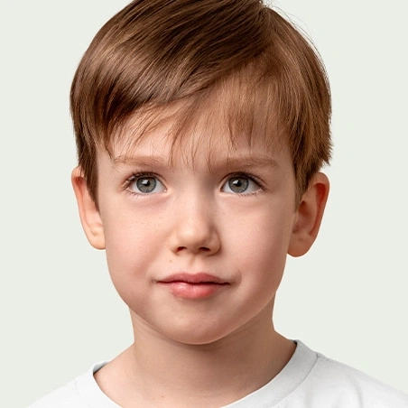 A young boy with brown hair and grey eyes looking directly at the camera.