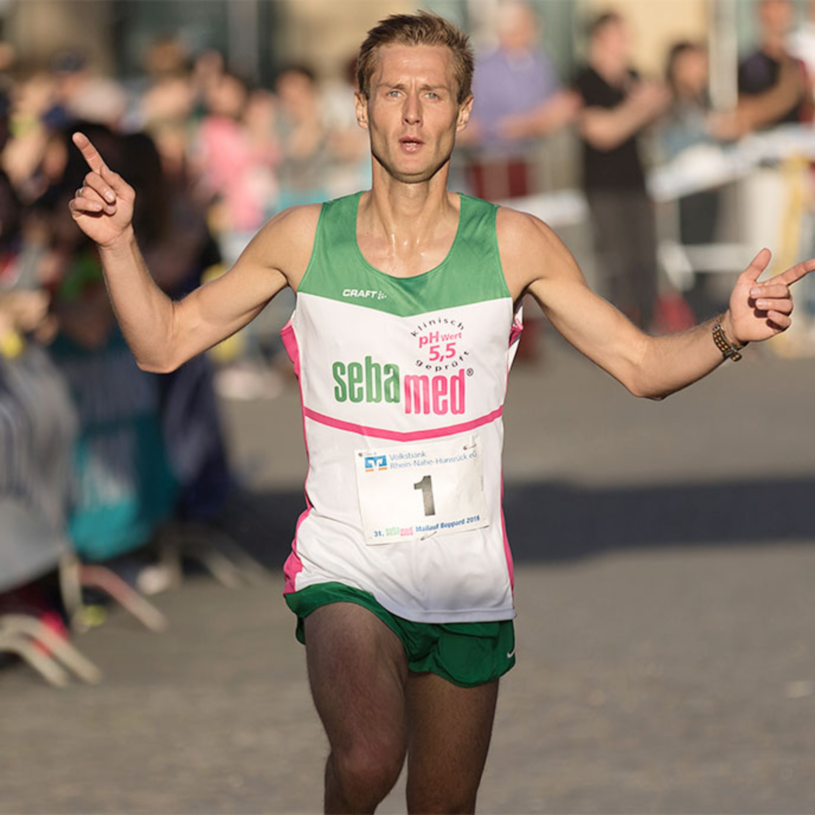 Runner with arms raised, celebrating victory, sport, competition, finish line