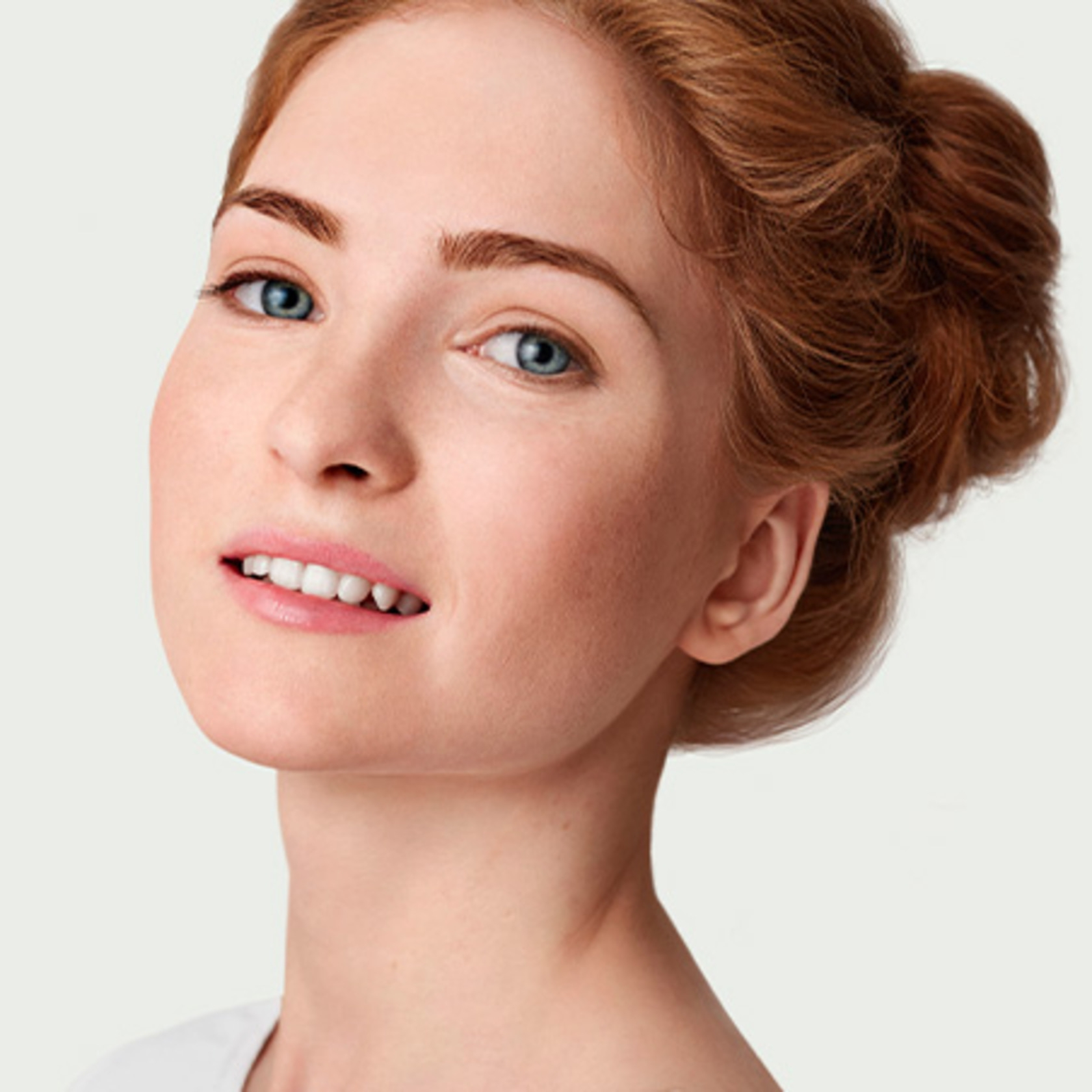 Portrait of a young woman with red hair and blue eyes smiling